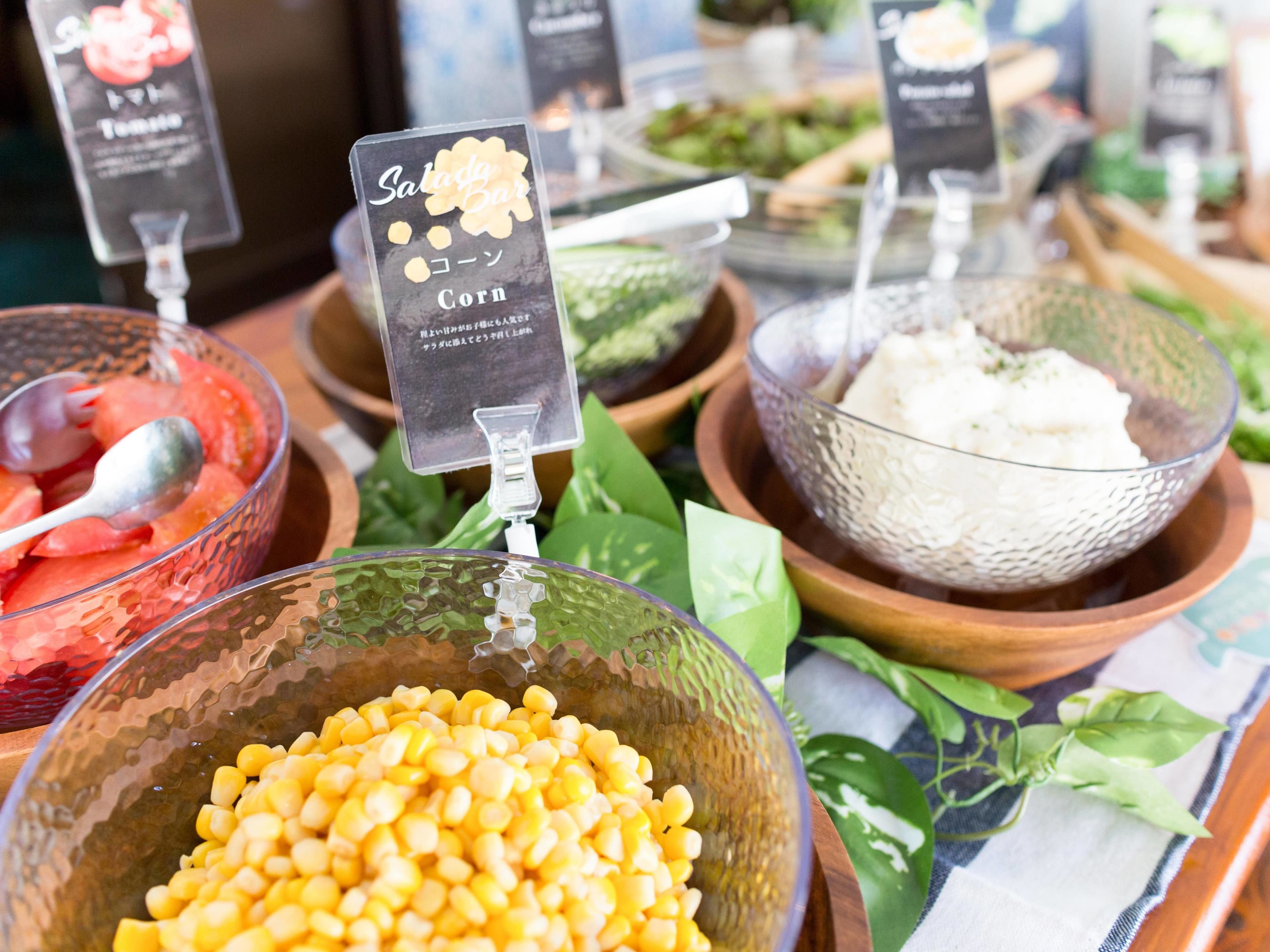 Un bufé con diferentes opciones de comida, incluyendo maíz, sandía y arroz.