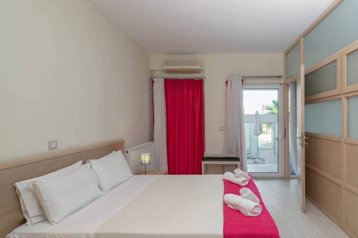 Une chambre d’hôtel avec un lit, un bureau, une chaise et une vue sur l’extérieur.