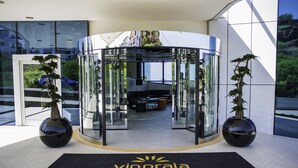 Puerta giratoria de acceso a un hotel con felpudo negro que dice "vippraia hotel".
