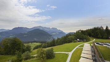 A scenic view of a mountainous landscape with a pathway leading to a covered outdoor seating area.