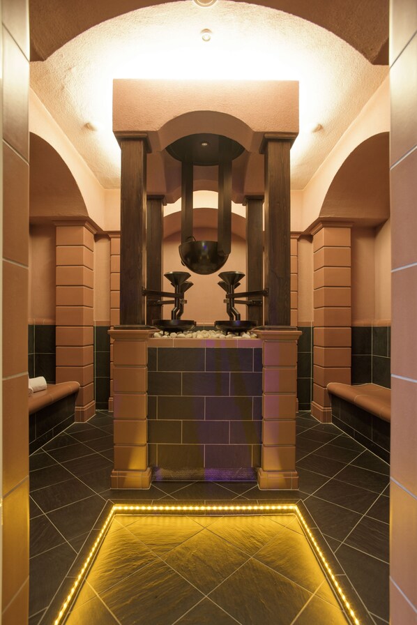 A modern bathroom with a central heated floor, a sink, and a mirror.
