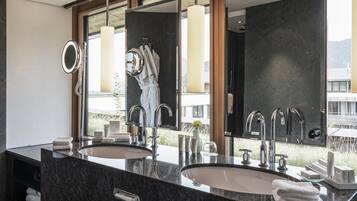 Ein modernes Badezimmer mit zwei Waschbecken, einem großen Spiegel und Blick auf ein Gebäude.