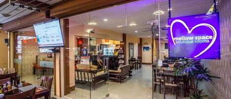 A modern interior with a neon heart sign, glass partitions, and a seating area with tables and chairs.