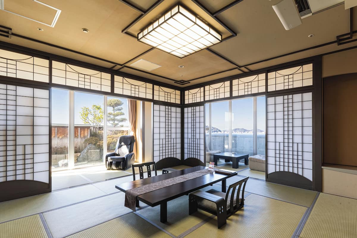 Ein traditioneller japanischer Raum mit Tatami-Böden, einem niedrigen Tisch und gleitenden Türen.