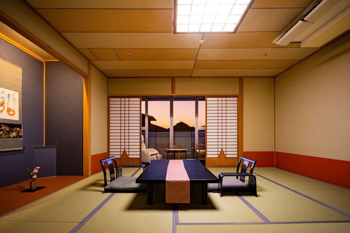 Ein traditioneller japanischer Raum mit Tatami-Böden, einem niedrigen Tisch und Shoji-Schirmwänden.