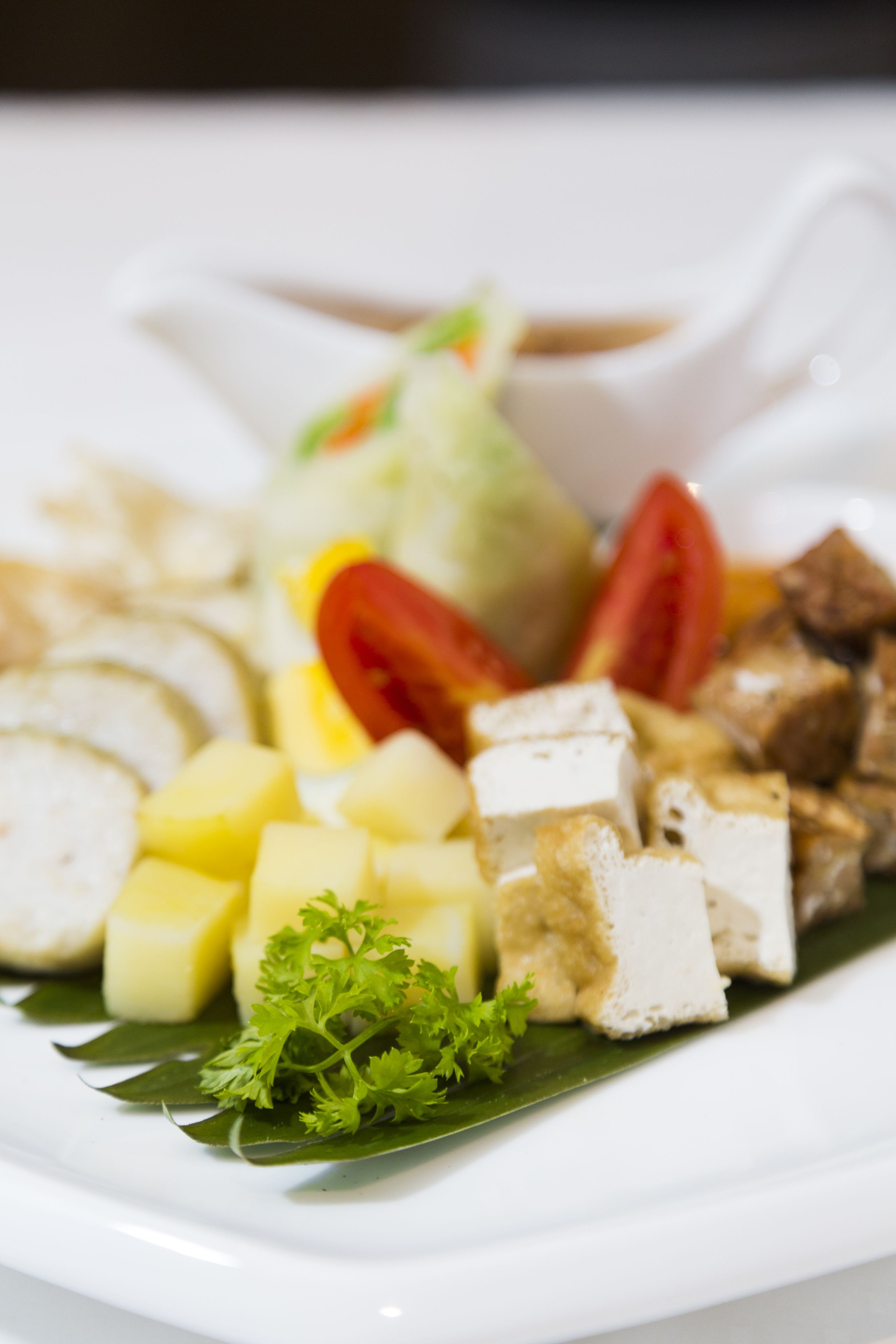 A plate of food with various items including tofu, potatoes, and vegetables.