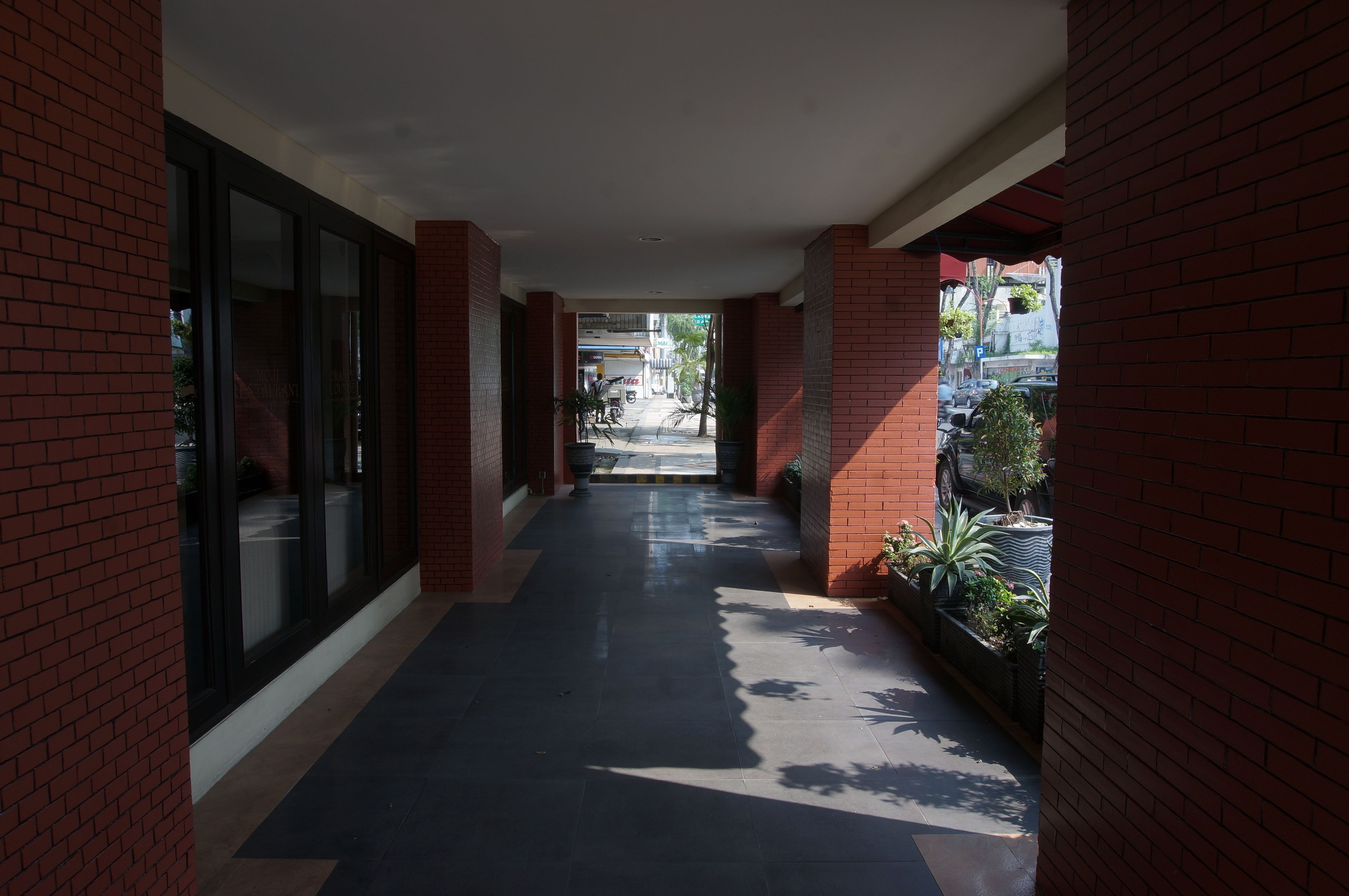 A corridor with red brick walls and large windows.
