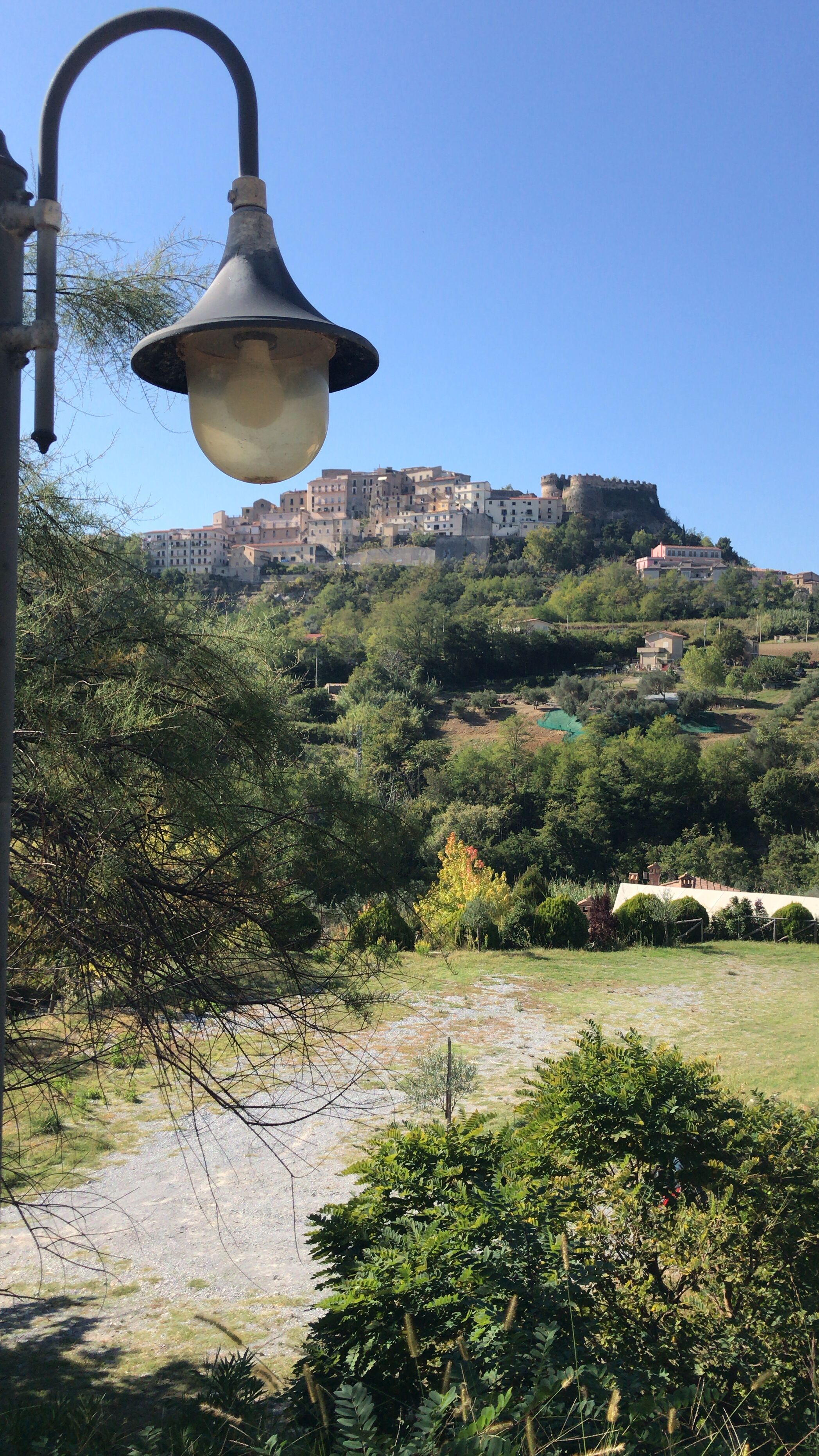 Una farola, un camino y una ladera con edificios.