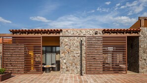 A modern building with a stone facade, wooden slats, and a tiled roof. - Monte da Esperança (Arronches)