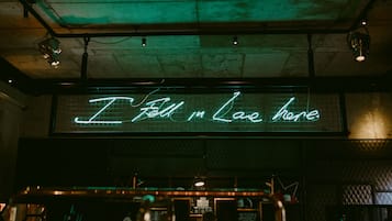 Um letreiro de neon com o texto 'Apaixonei-me aqui' em um café.