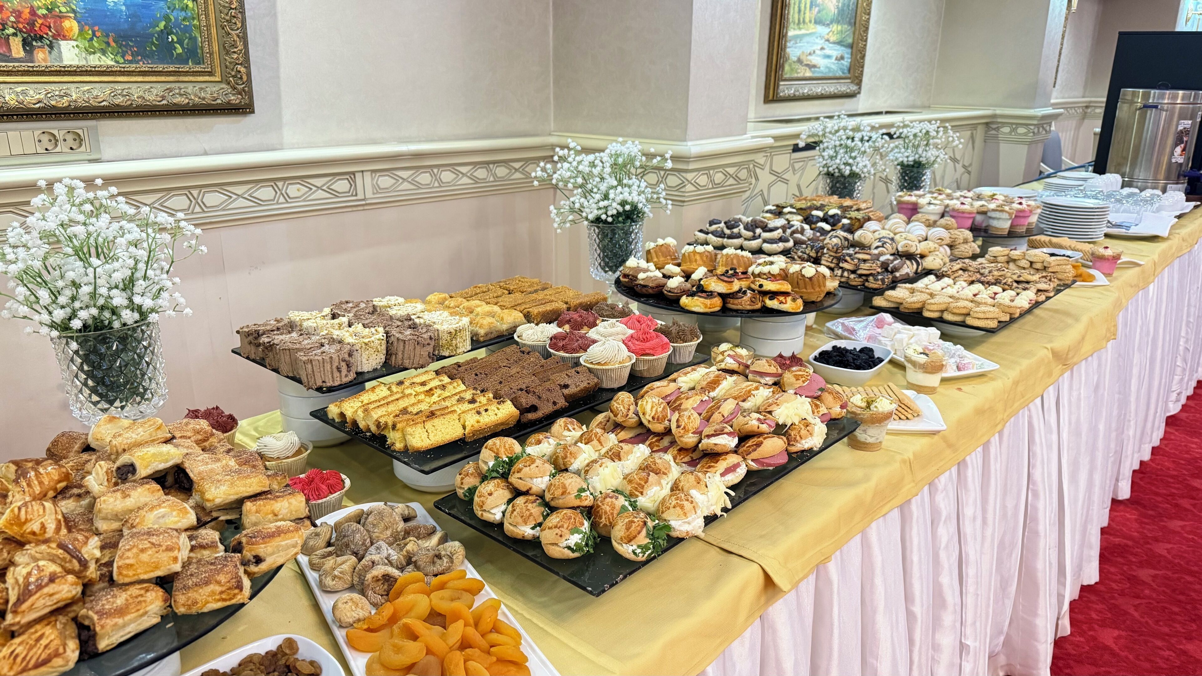 A buffet table with various pastries, desserts, and fruits.