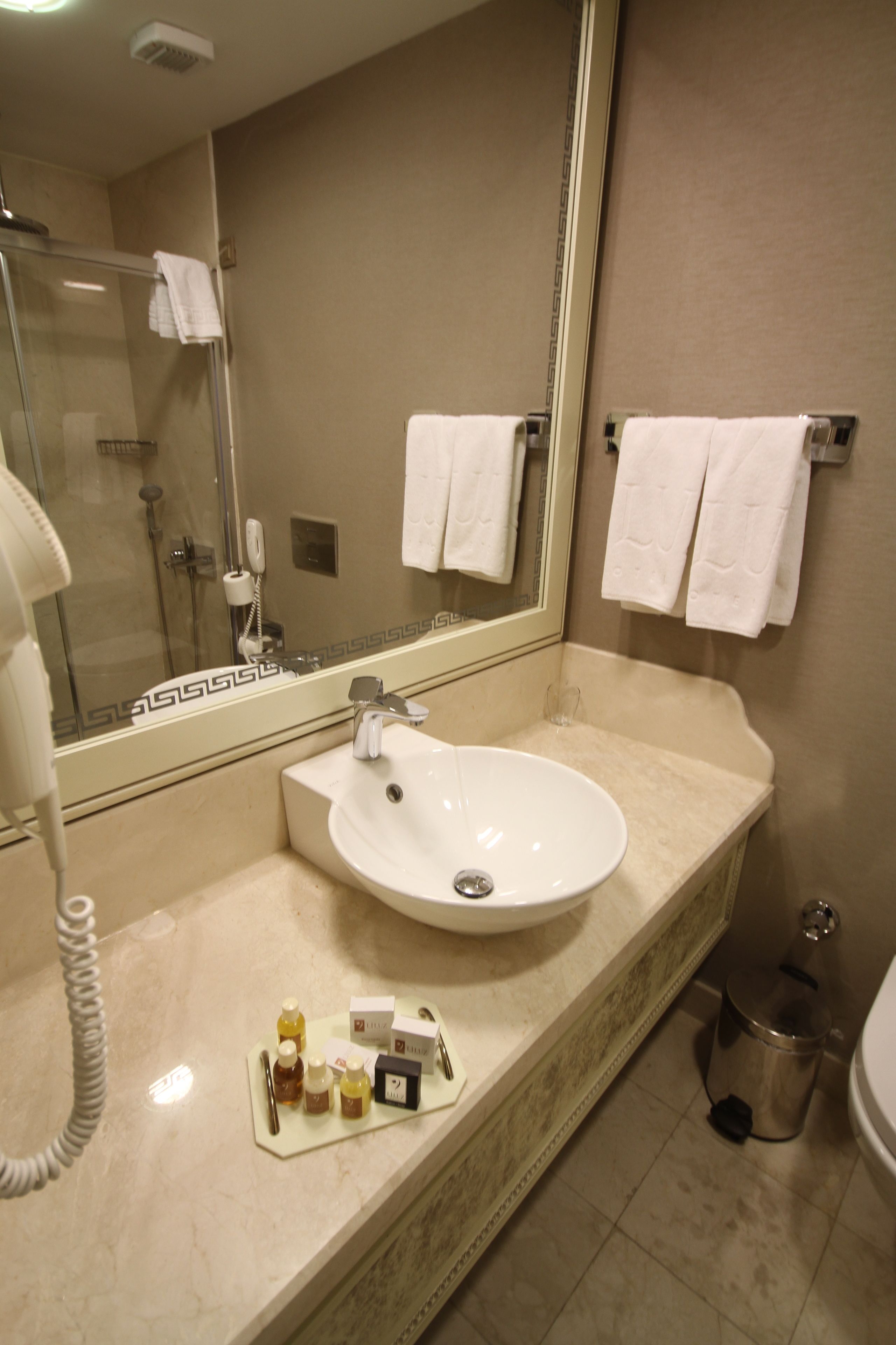 A bathroom with a sink, mirror, and toiletries.