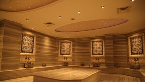 A spacious, well-lit room with a large central seating area, decorative wall panels, and a ceiling with embedded lighting. - Demir Hotel (Diyarbakir)