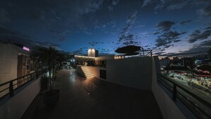 Un hotel moderno con un amplio espacio exterior que incluye una escalera que lleva a una terraza en la azotea.