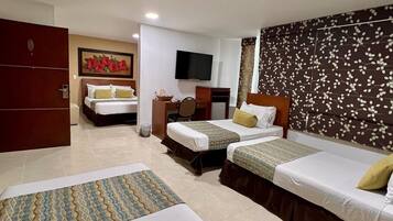 A hotel room with two single beds, a desk with a chair, a TV, and a wardrobe.