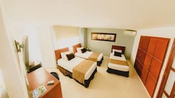 A hotel room with two single beds, a desk with a chair, a wardrobe, and a painting on the wall.