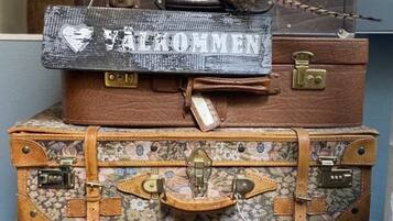A stack of vintage suitcases with a sign that reads "WELCOME".