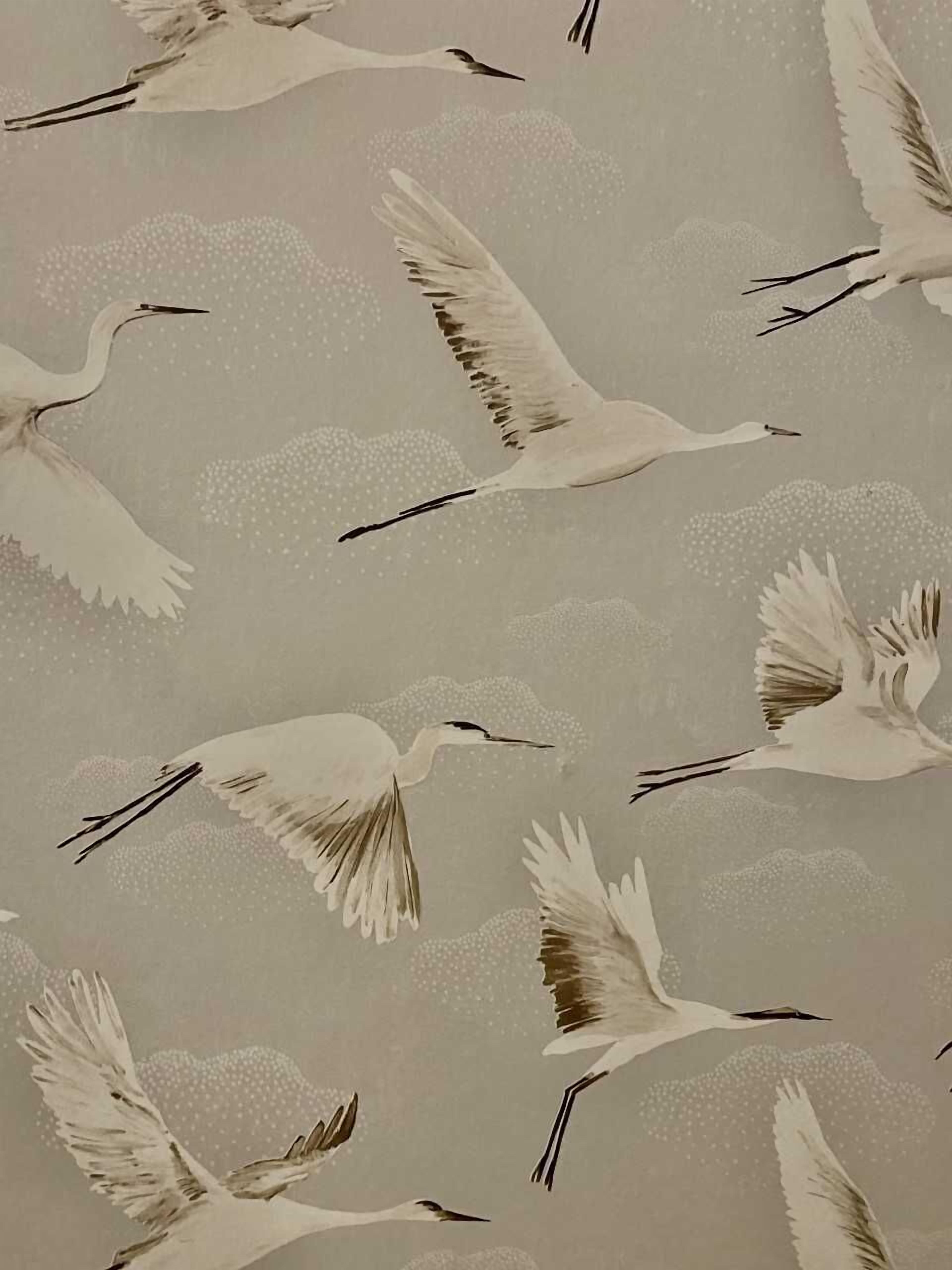 A wallpaper with a pattern of cranes in flight.
