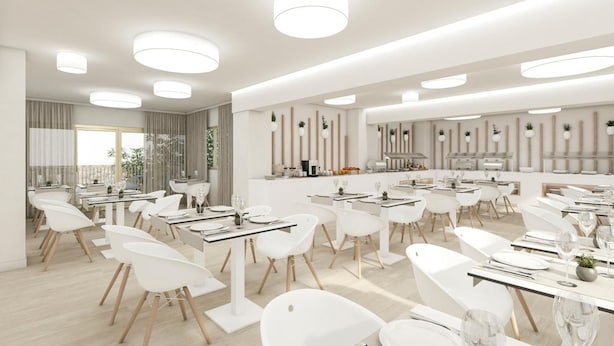 A modern restaurant with white furniture, multiple dining tables, and pendant lighting. - BLUESEA Arenal Tower (Llucmajor)