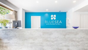 A reception area with a blue wall, a white door, and a reception desk. - BLUESEA Arenal Tower (Llucmajor)