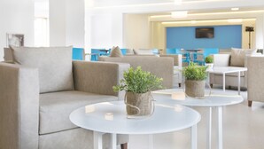 A modern hotel lobby with sofas, tables, and potted plants. - BLUESEA Arenal Tower (Llucmajor)