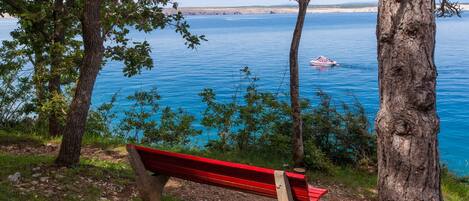 Un banc donnant sur un lac, avec un bateau visible au loin.