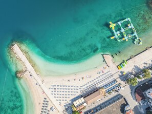 Vista aérea de una playa con un estacionamiento y un edificio.