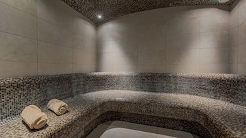 Relax in a serene spa room with a curved seating area and mosaic tiles.