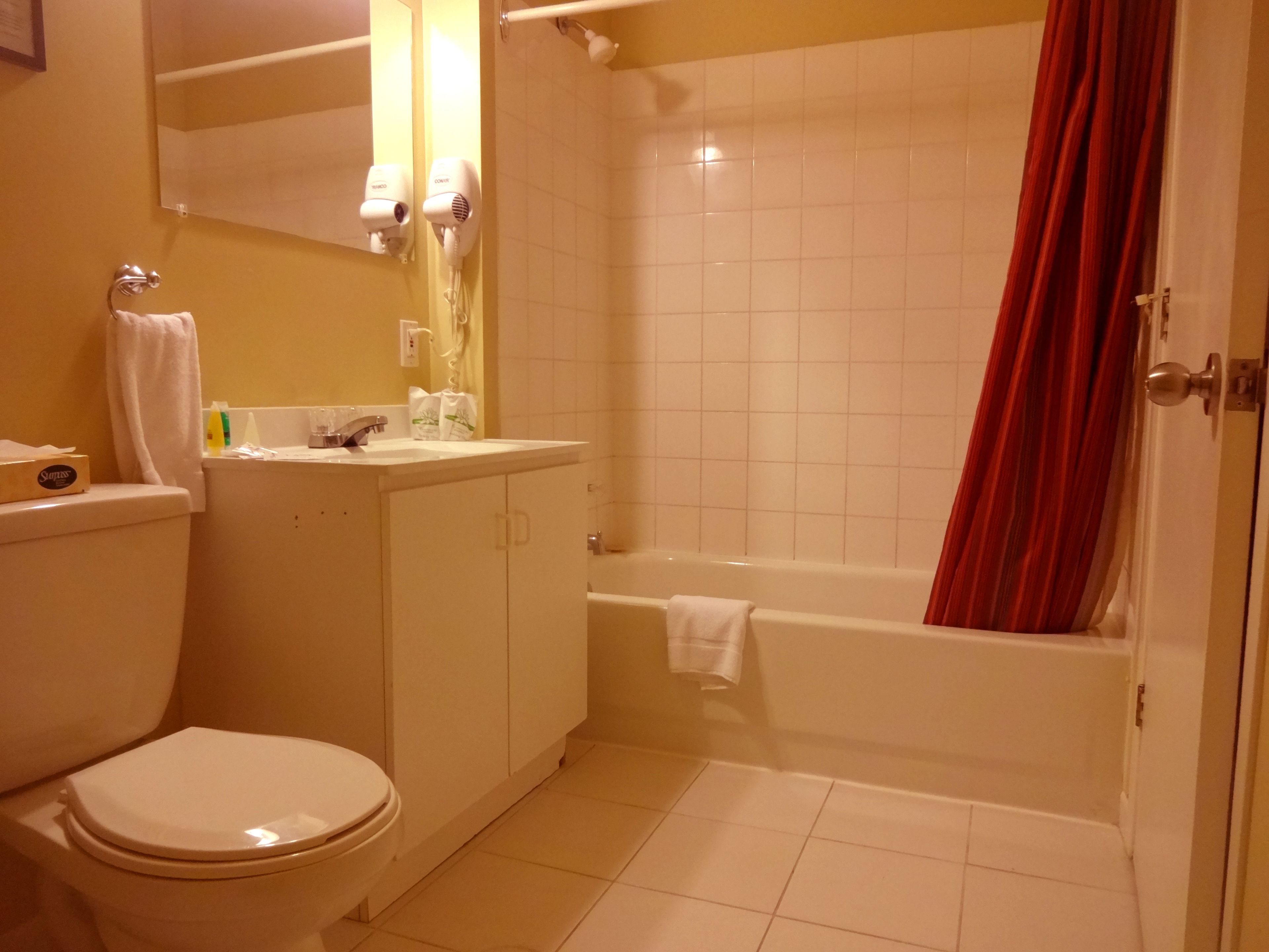 A bathroom with a toilet, sink, and bathtub.
