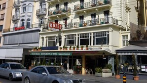 A multi-story hotel with balconies, a restaurant at the ground level, and a car in the foreground. - Hotel Parc & Lac (Montreux)