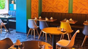 A restaurant with round tables, chairs, and hanging pendant lights. - Hotel Parc & Lac (Montreux)