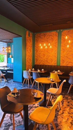A restaurant with round tables, chairs, and hanging pendant lights. - Hotel Parc & Lac (Montreux)
