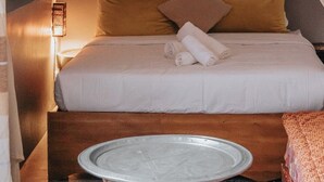 Una cama con dosel, un cuadro y una lámpara de noche.