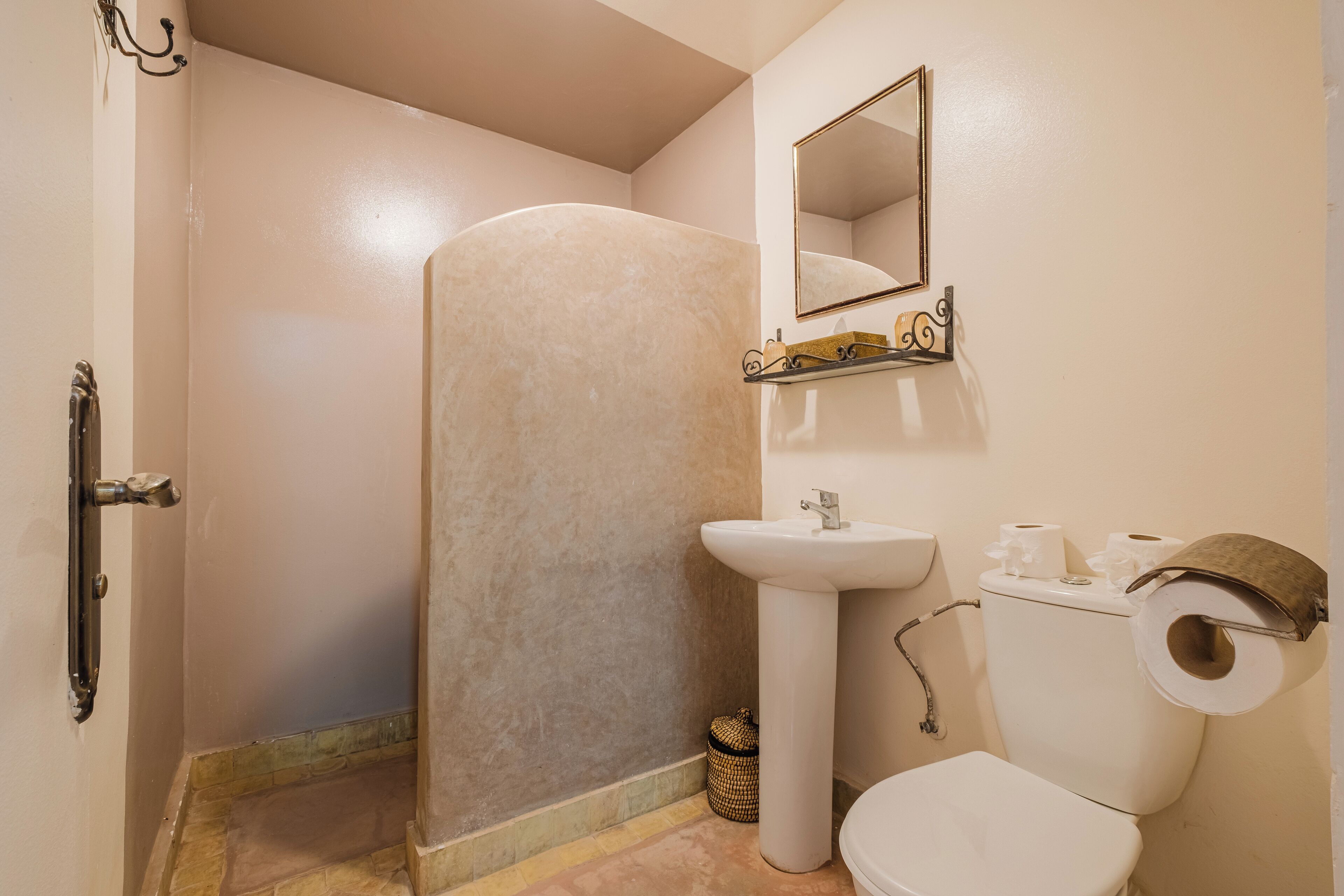 Un baño con ducha, lavabo, inodoro y espejo.