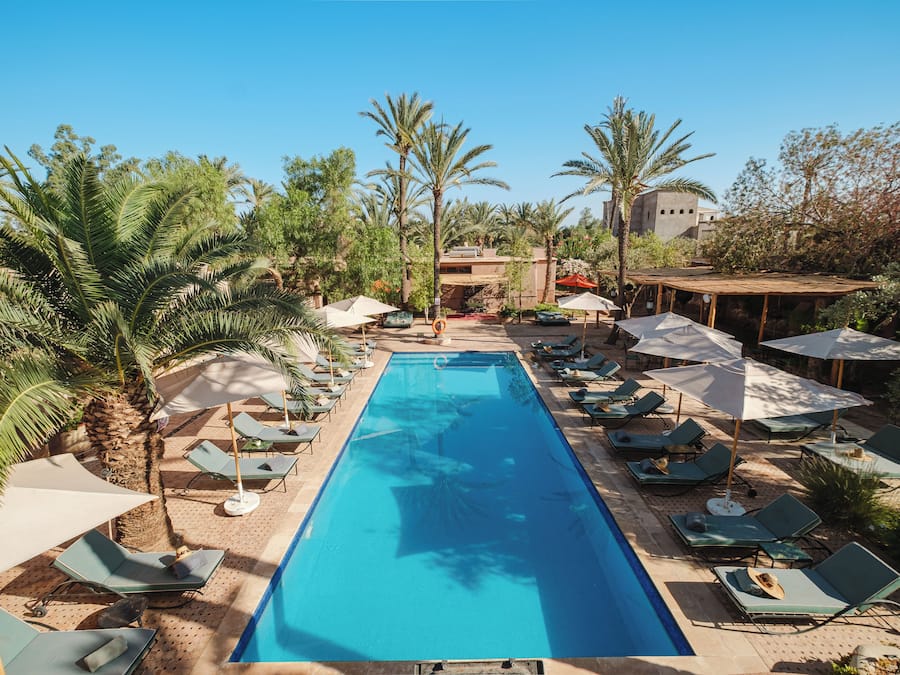 Een buitenzwembad, parasols bij het zwembad en ligstoelen