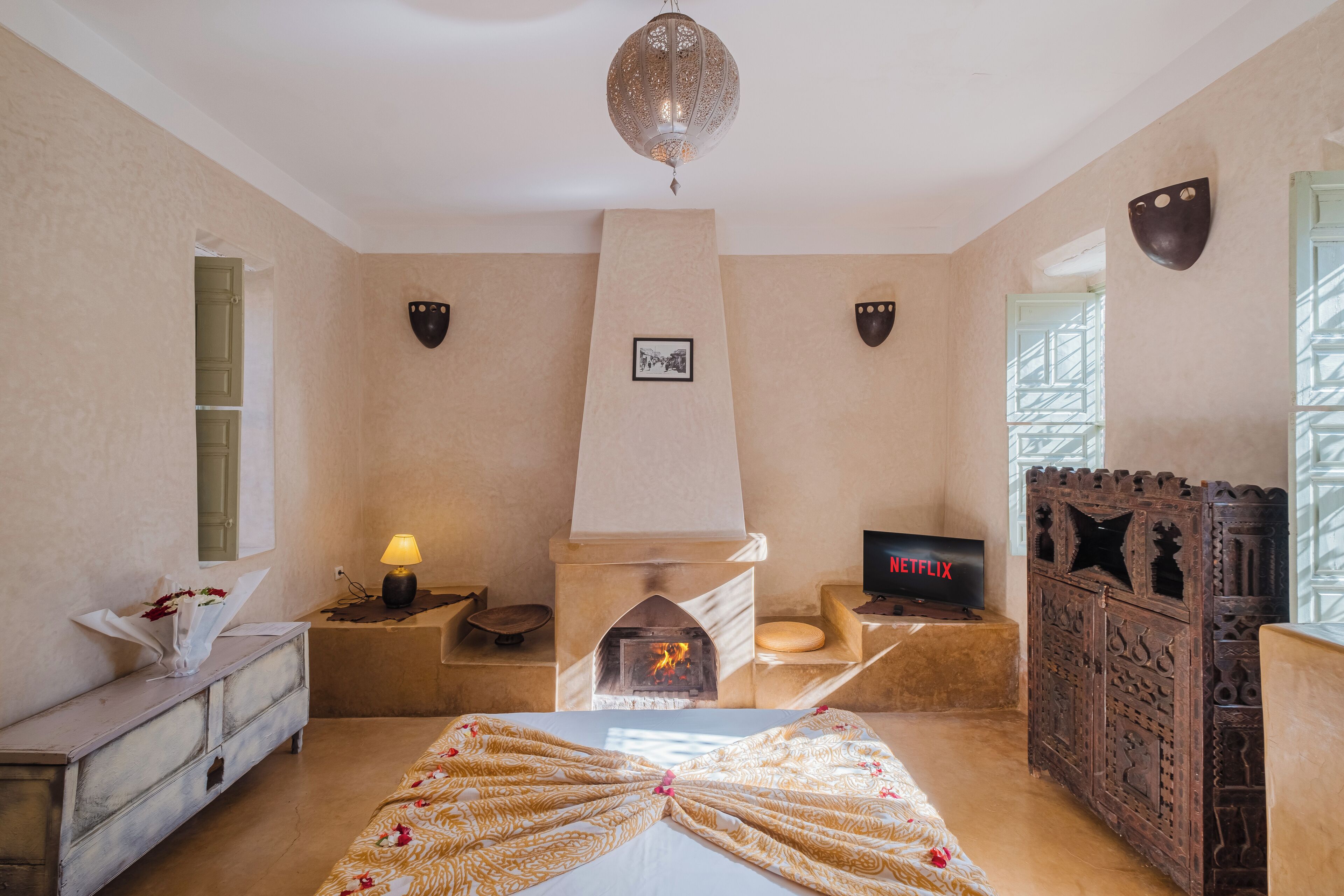 Una habitación con chimenea, televisión y un aparador decorativo.