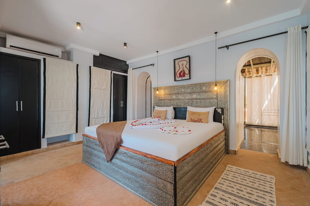 Un dormitorio amplio con una cama grande, un armario y un arco que da a un balcón.