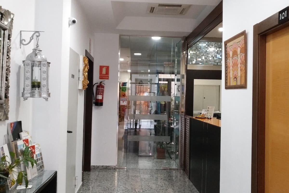 Un couloir doté d’un sol en marbre, un comptoir d’accueil, un extincteur et une porte portant l’inscription « 101 ».
