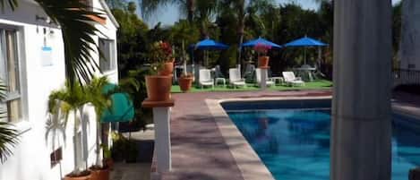 Una piscina al aire libre, tumbonas