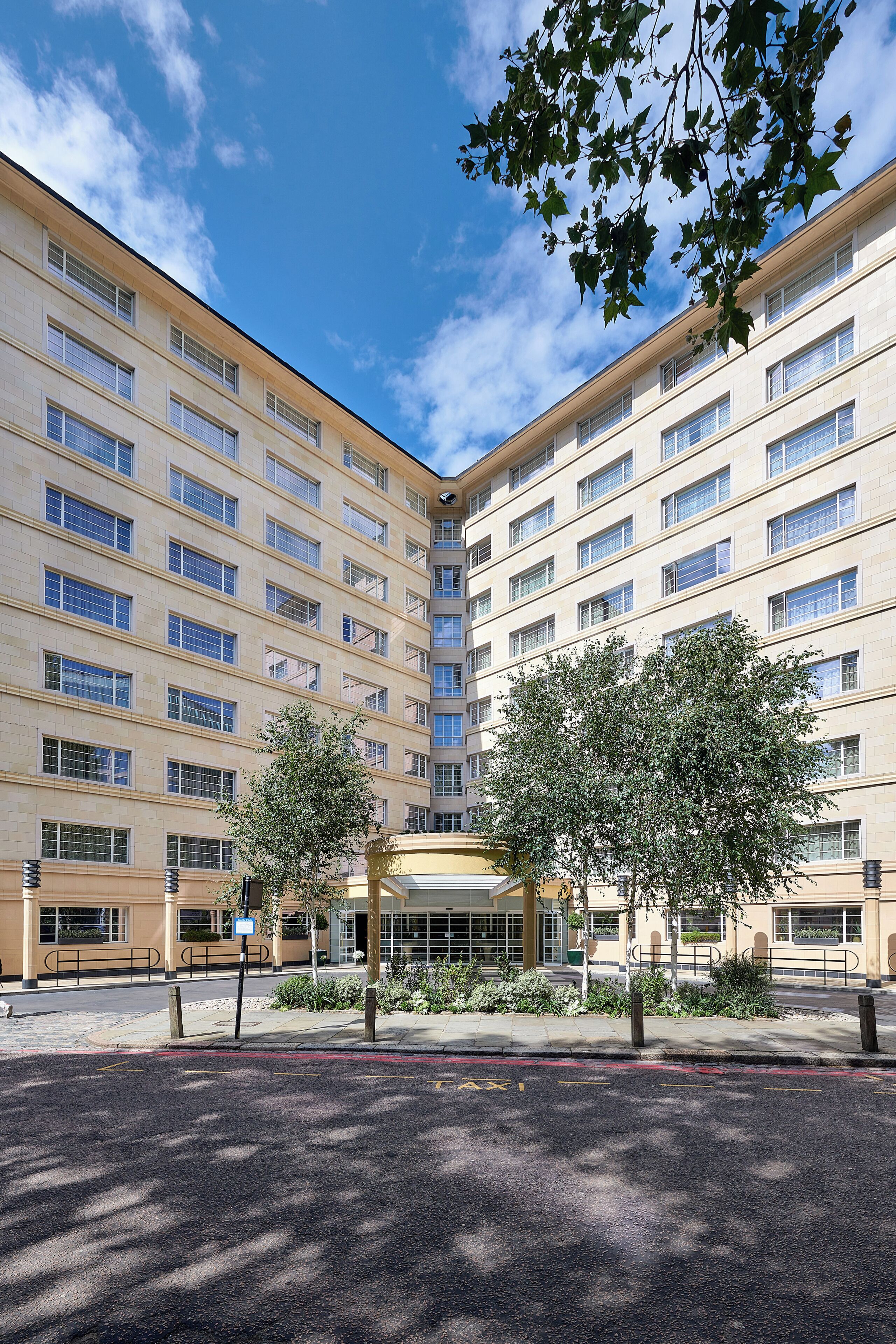 A multi-story hotel with a symmetrical facade, large windows, and a central entrance.