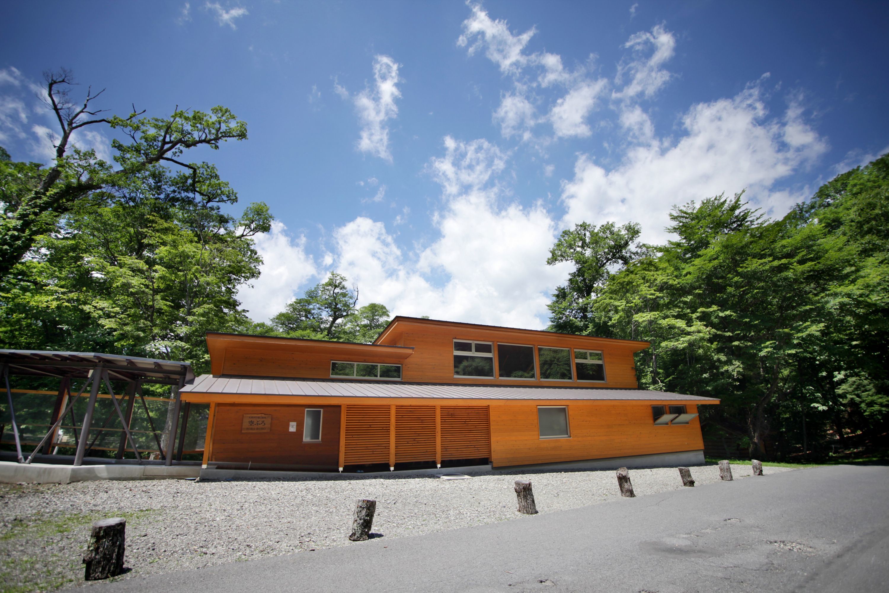 A modern building with a flat roof, large windows, and a wooden facade.