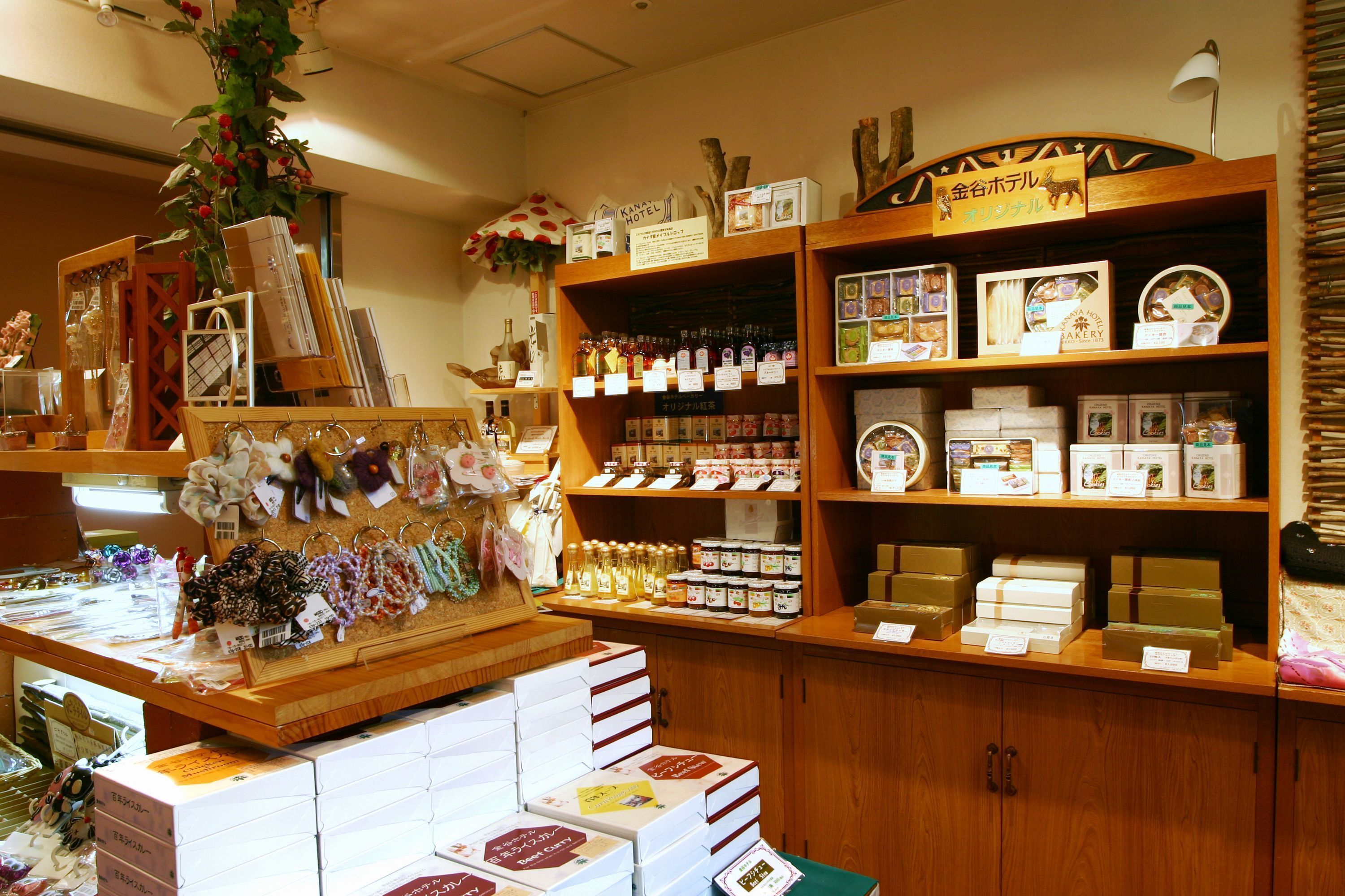 A retail space with wooden shelves displaying various products, including books, boxes, and decorative items.