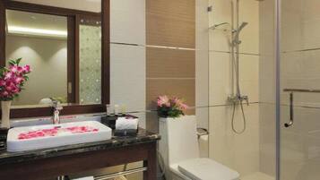 Ein Badezimmer mit Waschbecken, Spiegel, Dusche und Toilette.