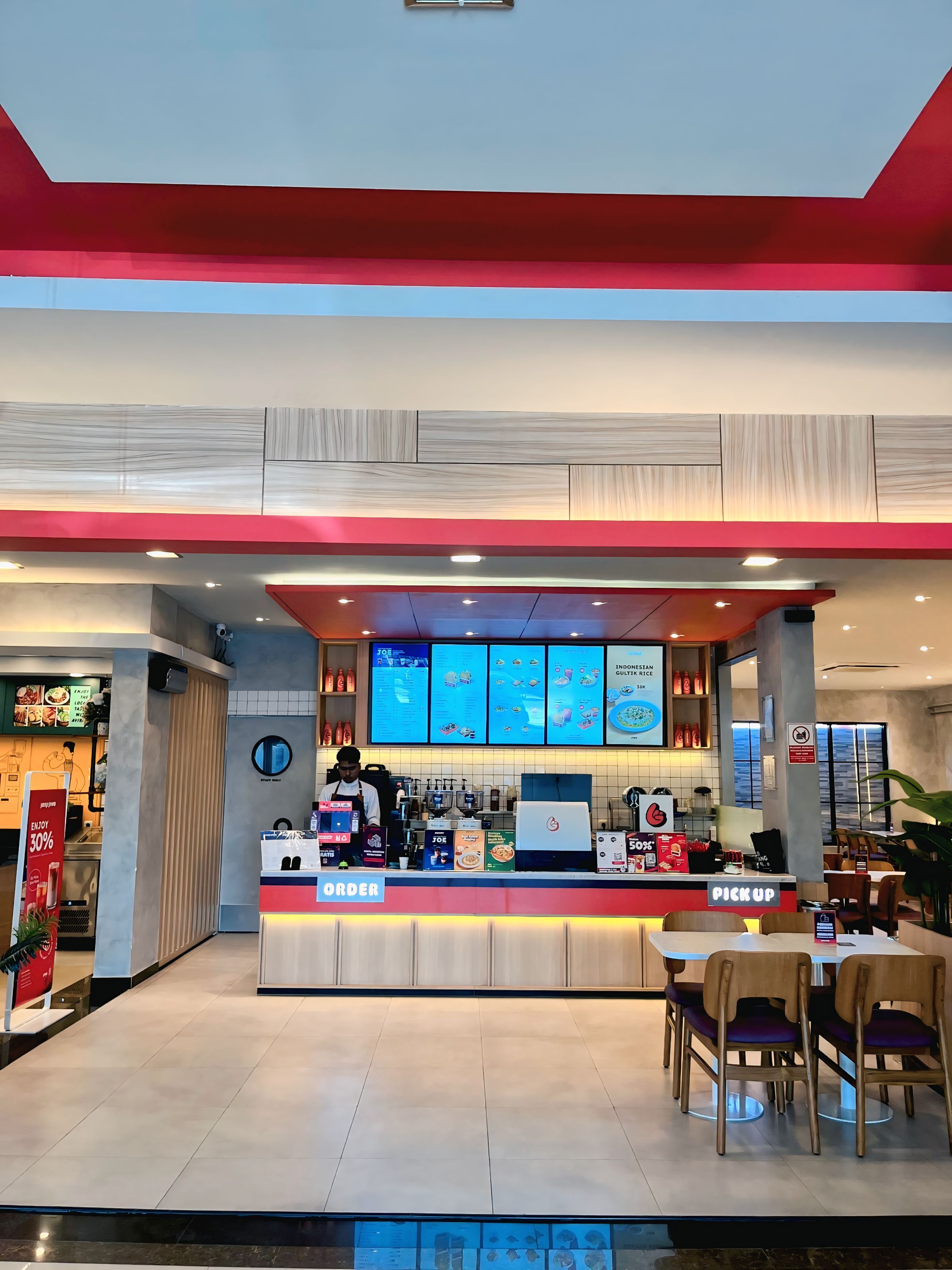 Un restaurant moderne doté d’un comptoir pour passer et récupérer les commandes, d’un présentoir pour afficher le menu et d’un espace réservé aux clients.