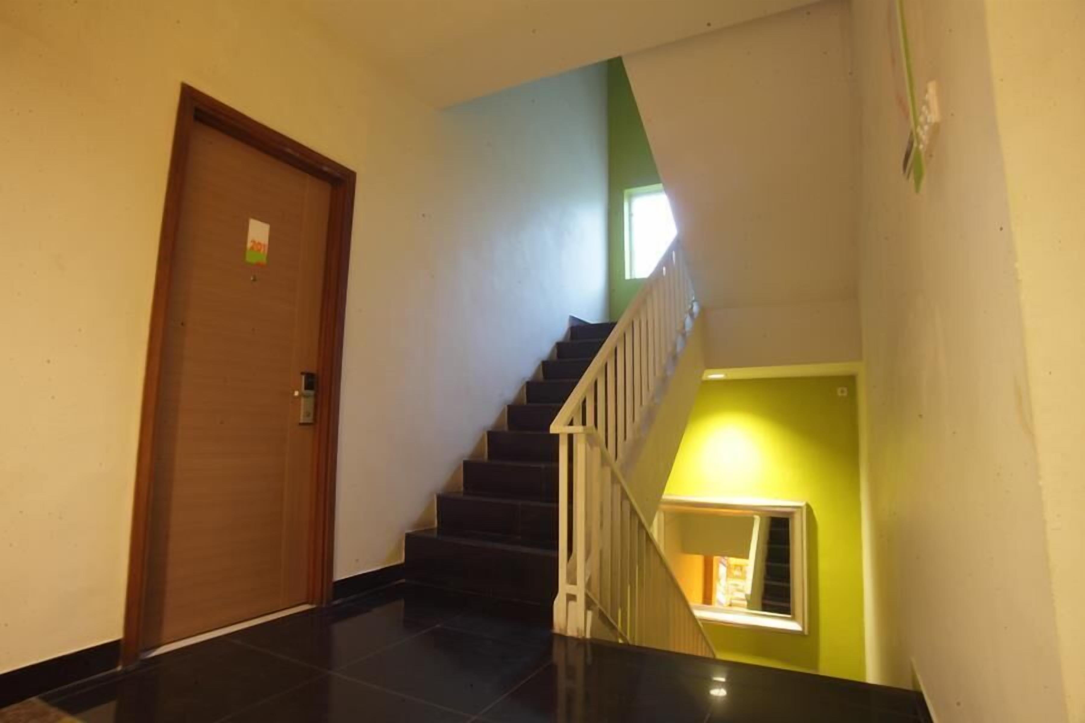 A staircase with a wooden door on the left and a bright green wall on the right.