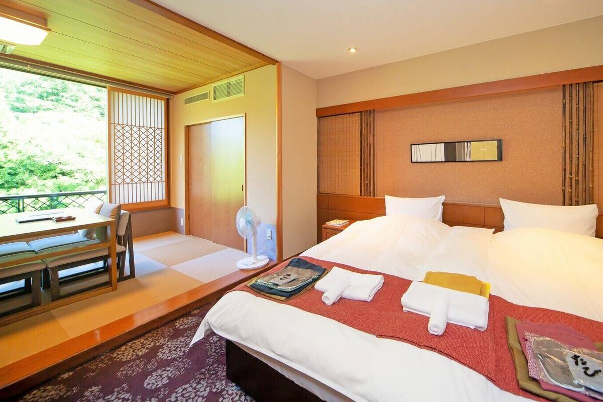 A hotel room with a bed, a desk, and a chair.