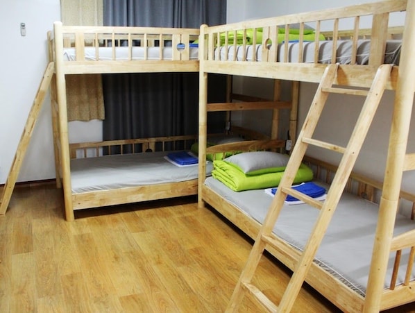 A bunk bed room with two beds, wooden flooring, and a window with curtains. - Welcome Busan Guesthouse (Busan)