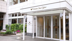 The exterior of the Wishton Hotel Yukari with a modern facade, large glass doors, and a signboard. - Wishton Hotel Yukari (Sakura)