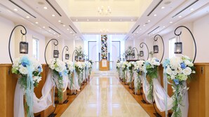 A church interior with pews adorned with floral arrangements and a central altar. - Wishton Hotel Yukari (Sakura)
