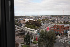 A cityscape with a train, buildings, and a pedestrian bridge. - Wishton Hotel Yukari (Sakura)